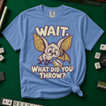 Wait What Did You Throw T-Shirt in Blue Jean, knotted flat lay on a green mahjong mat - a wide-eyed fluffy bat with huge golden ears leaning in over a fallen dot tile - "WAIT. WHAT DID YOU THROW?" in cream bubble letters