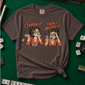 I Threw It Then I Needed It T-Shirt in Espresso, knotted flat lay on a green mahjong mat - a retro comic two-panel scene of a woman smugly flicking away a mahjong tile, then panicking when she needs it, with the words "I THREW IT. THEN I NEEDED IT."