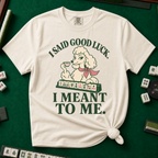 I Said Good Luck T-Shirt in Ivory - knotted tee flat lay on a green mahjong mat with tiles, printed with a cream poodle in a pink scarf holding a teacup behind a rack of mahjong tiles, with the words I SAID GOOD LUCK. I MEANT TO ME.