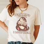 Woman wearing the I Can't Pass These I Love Them T-Shirt in Ivory - lovestruck otter hugging three mahjong tiles to her chest - "I CAN'T PASS THESE. I LOVE THEM." in cream retro letters