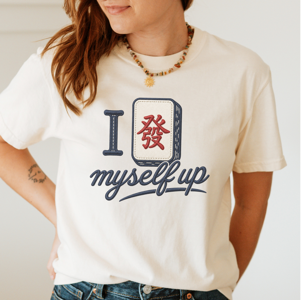 Woman wearing the I Set Myself Up T-Shirt in Ivory - a stitched-look varsity rebus - a navy letter I beside a cream fa dragon tile with the red character, over "myself up" in navy script