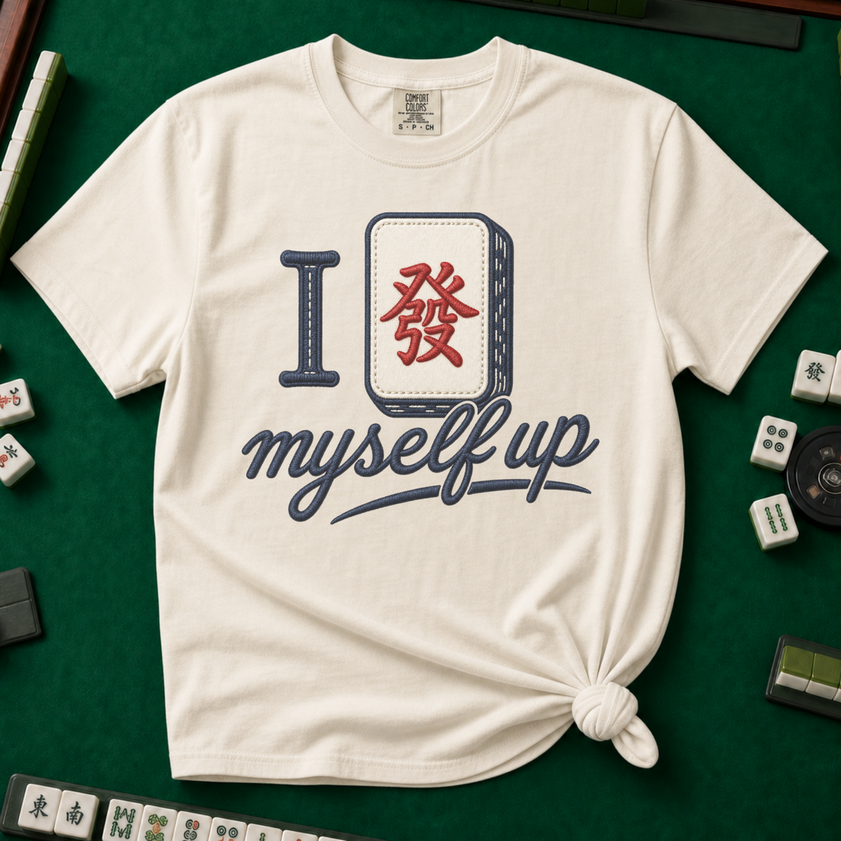 I Set Myself Up T-Shirt in Ivory, knotted flat lay on a green mahjong mat - a stitched-look varsity rebus - a navy letter I beside a cream fa dragon tile with the red character, over "myself up" in navy script