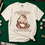 I Can't Pass These I Love Them T-Shirt in Ivory, knotted flat lay on a green mahjong mat - lovestruck otter hugging three mahjong tiles to her chest - "I CAN'T PASS THESE. I LOVE THEM." in cream retro letters