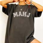 Woman wearing the MAHJ Varsity T-Shirt in Pepper, oversized fit - "MAHJ" in big white varsity arch letters with a stitched letterman look