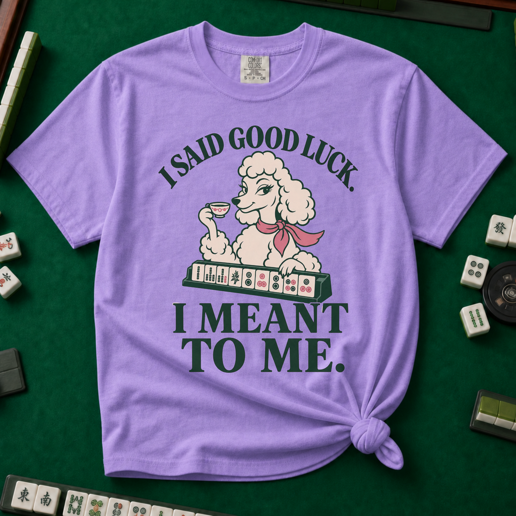I Said Good Luck T-Shirt in Violet - knotted tee flat lay on a green mahjong mat with tiles, printed with a cream poodle in a pink scarf holding a teacup behind a rack of mahjong tiles, with the words I SAID GOOD LUCK. I MEANT TO ME.