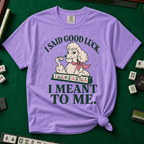 I Said Good Luck T-Shirt in Violet - knotted tee flat lay on a green mahjong mat with tiles, printed with a cream poodle in a pink scarf holding a teacup behind a rack of mahjong tiles, with the words I SAID GOOD LUCK. I MEANT TO ME.