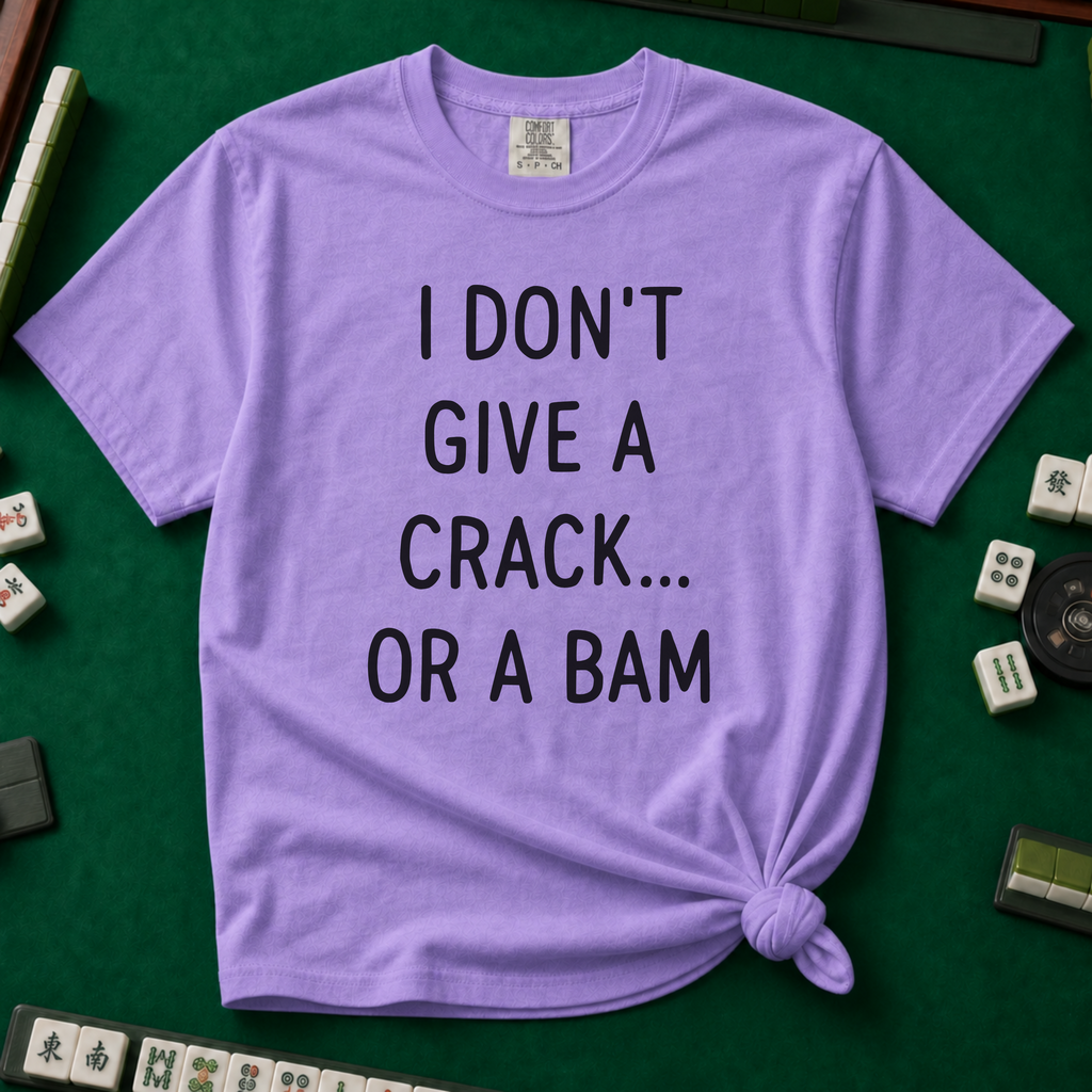I Don't Give A Crack Or A Bam T-Shirt in Violet, knotted flat lay on a green mahjong mat - "I DON'T GIVE A CRACK... OR A BAM" in black handwritten-style letters