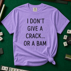 I Don't Give A Crack Or A Bam T-Shirt in Violet, knotted flat lay on a green mahjong mat - "I DON'T GIVE A CRACK... OR A BAM" in black handwritten-style letters