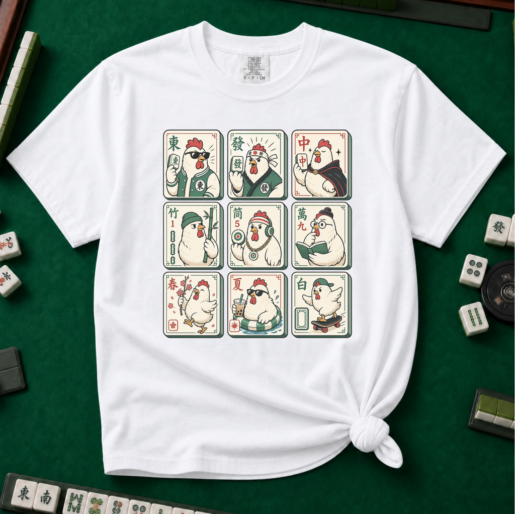 Mahjong Chicken Tiles T-Shirt in White, knotted flat lay on a green mahjong mat - a 3x3 grid of mahjong tiles, each starring a cartoon chicken with its own personality - varsity jacket, karate gi, cape, beanie, headphones, bookworm glasses, cherry blossom, pool floatie and skateboard