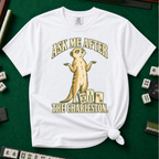 Ask Me After The Charleston T-Shirt in White, knotted flat lay on a green mahjong mat - shrugging meerkat standing beside three mahjong tiles - "ASK ME AFTER THE CHARLESTON." in cream collegiate letters