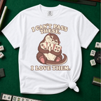 I Can't Pass These I Love Them T-Shirt in White, knotted flat lay on a green mahjong mat - lovestruck otter hugging three mahjong tiles to her chest - "I CAN'T PASS THESE. I LOVE THEM." in cream retro letters