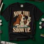 Now You Show Up Shirt in Black - knotted tee on a green mahjong mat with scattered tiles, printed with a basset hound peeking over a row of mahjong tiles and the words Now You Show Up