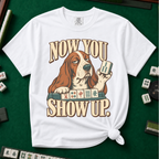Now You Show Up Shirt in White - knotted tee on a green mahjong mat with scattered tiles, printed with a basset hound peeking over a row of mahjong tiles and the words Now You Show Up