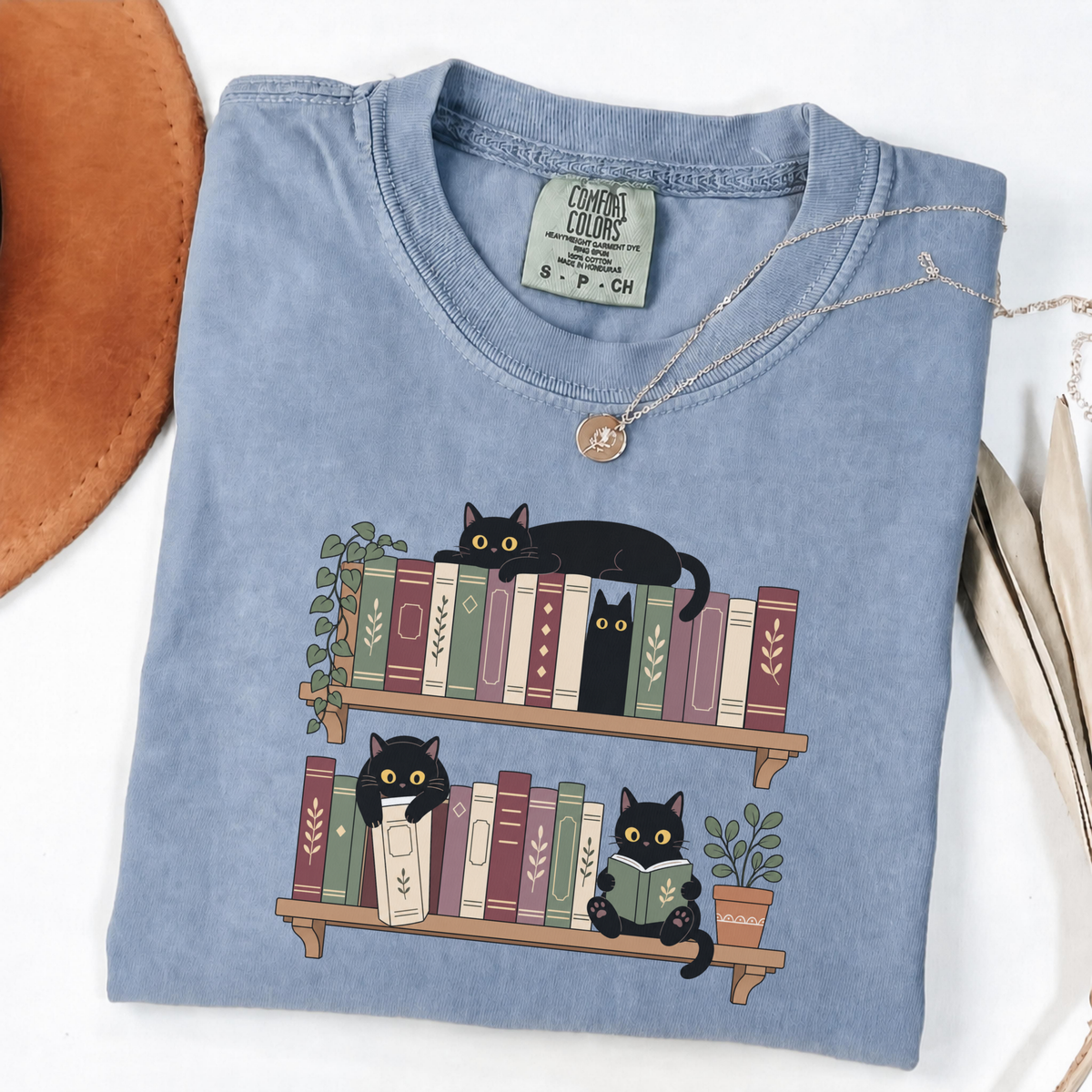 Blue Jean Comfort Colors book-lover shirt featuring black cats among colourful bookshelves