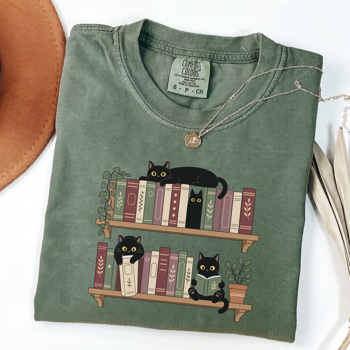 Moss Comfort Colors book-lover shirt featuring black cats among colourful bookshelves
