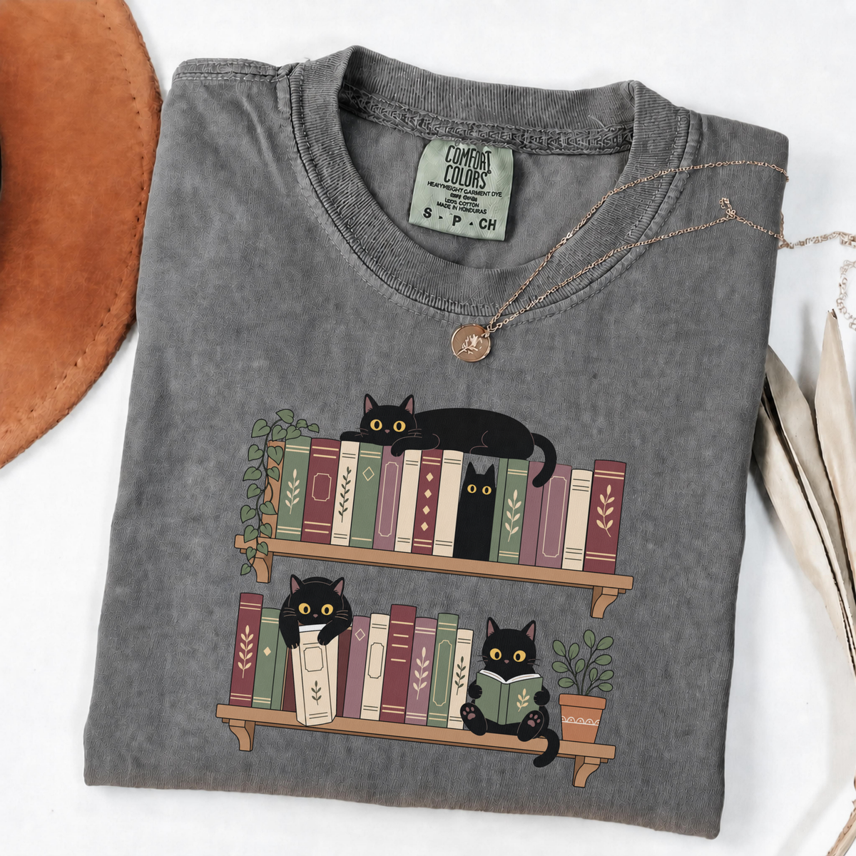 Pepper Comfort Colors book-lover shirt featuring black cats among colourful bookshelves