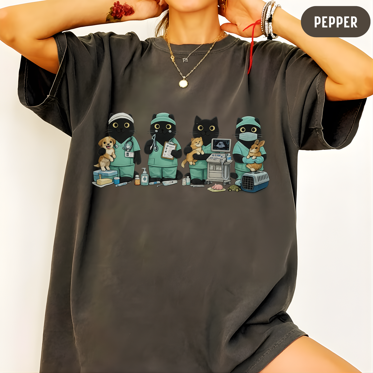 A person wearing a dark charcoal gray oversized t-shirt with a colorful graphic of four cartoon animals dressed as veterinarians. The image has a 'PEPPER' color label overlay in the top right corner.
