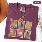 Berry shirt with six vintage-style postage stamps featuring cats reading and resting on books.
