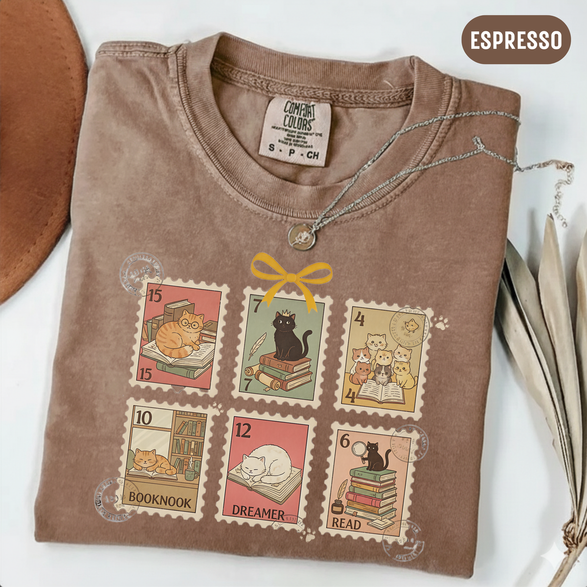 Espresso shirt with six vintage-style postage stamps featuring cats reading and resting on books.