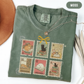 Moss shirt with six vintage-style postage stamps featuring cats reading and resting on books.