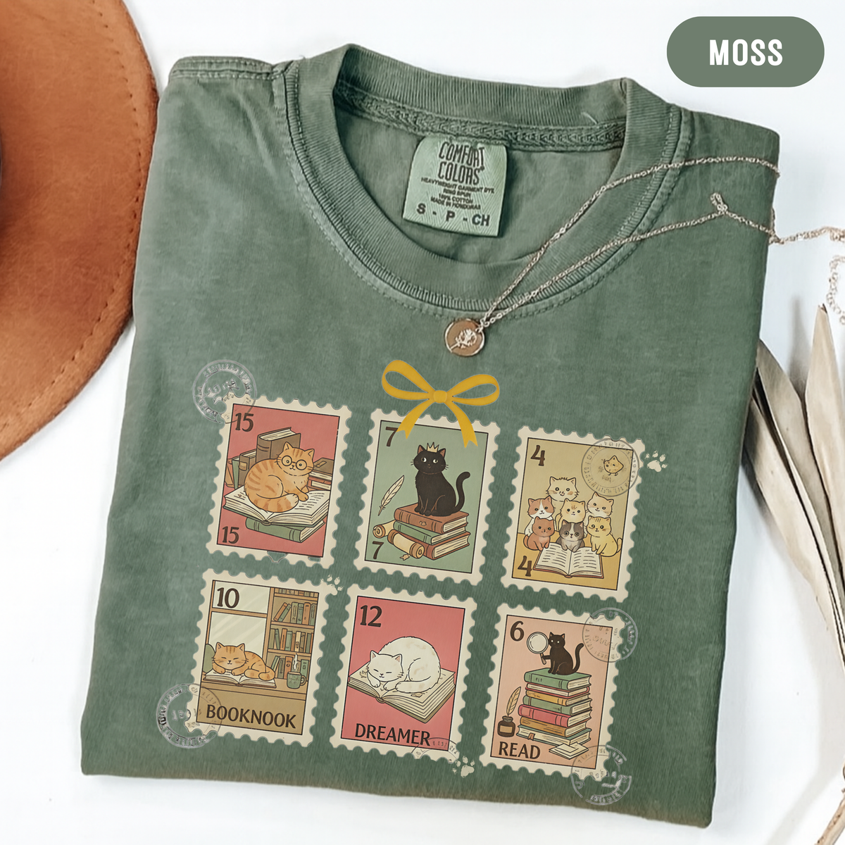 Moss shirt with six vintage-style postage stamps featuring cats reading and resting on books.