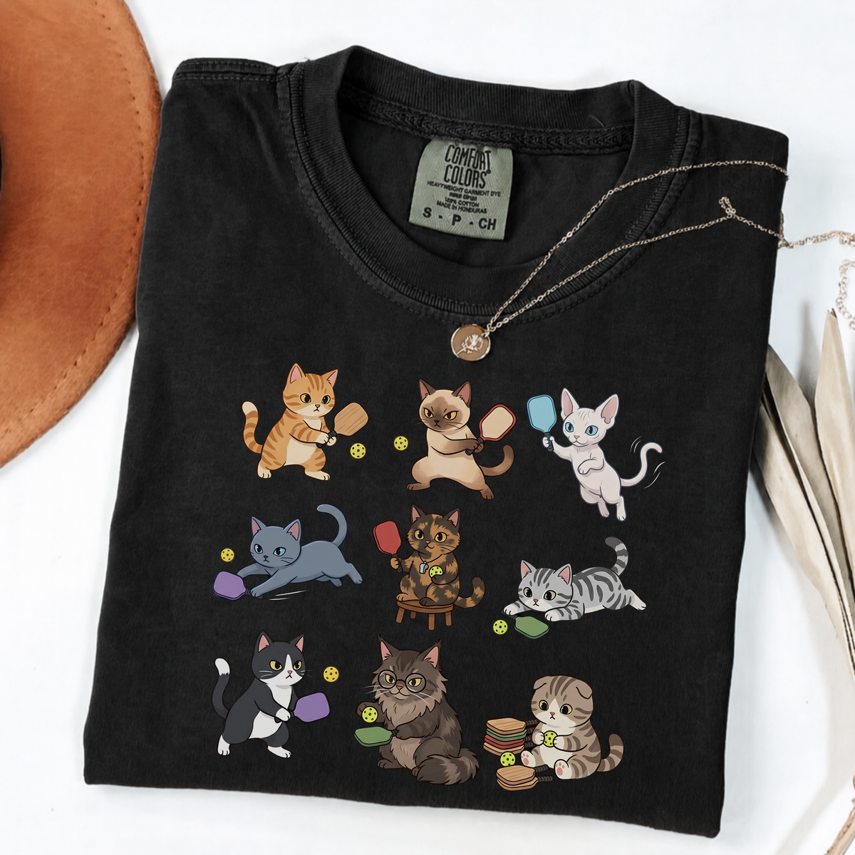 Black graphic T-shirt with nine cartoon cats playing pickleball