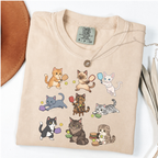 Ivory graphic T-shirt with nine cartoon cats playing pickleball