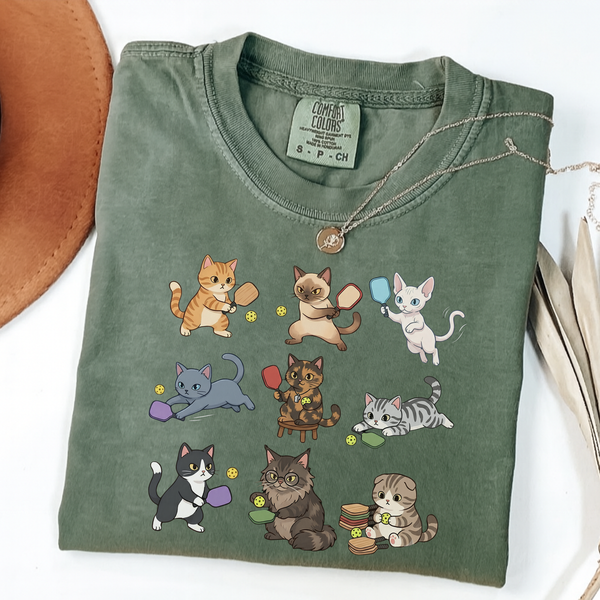 Moss graphic T-shirt with nine cartoon cats playing pickleball