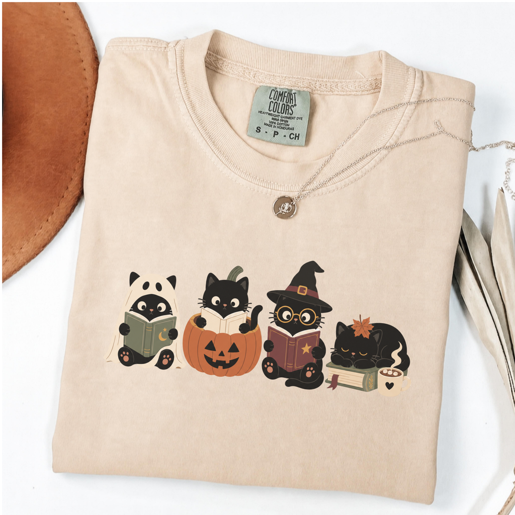 Ivory Comfort Colors Halloween shirt featuring four black cats reading books in spooky costumes