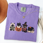 Violet Comfort Colors Halloween shirt featuring four black cats reading books in spooky costumes