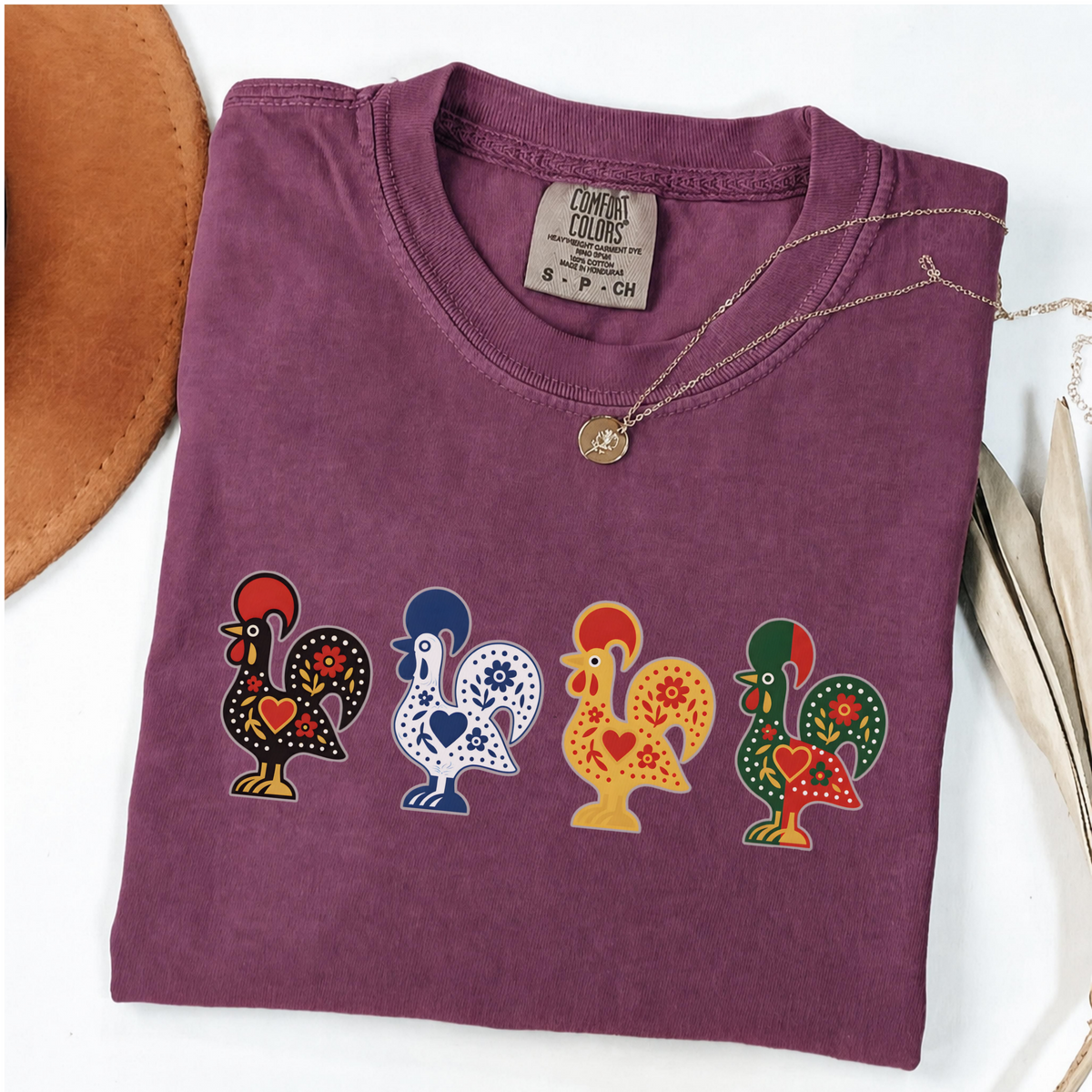 Berry garment-dyed T-shirt featuring four colorful Portuguese folk-art roosters in a row