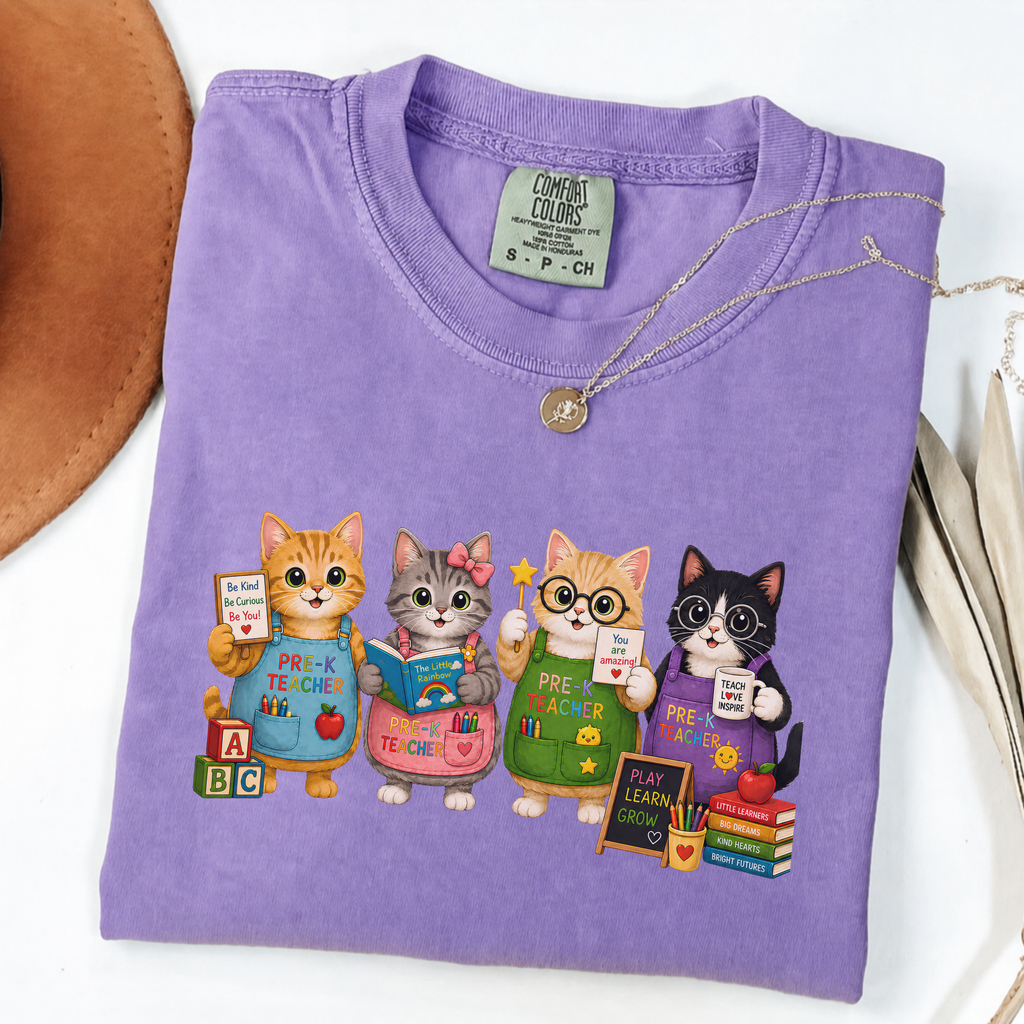 Violet T-shirt with four cartoon cats dressed as colorful pre-K teachers.