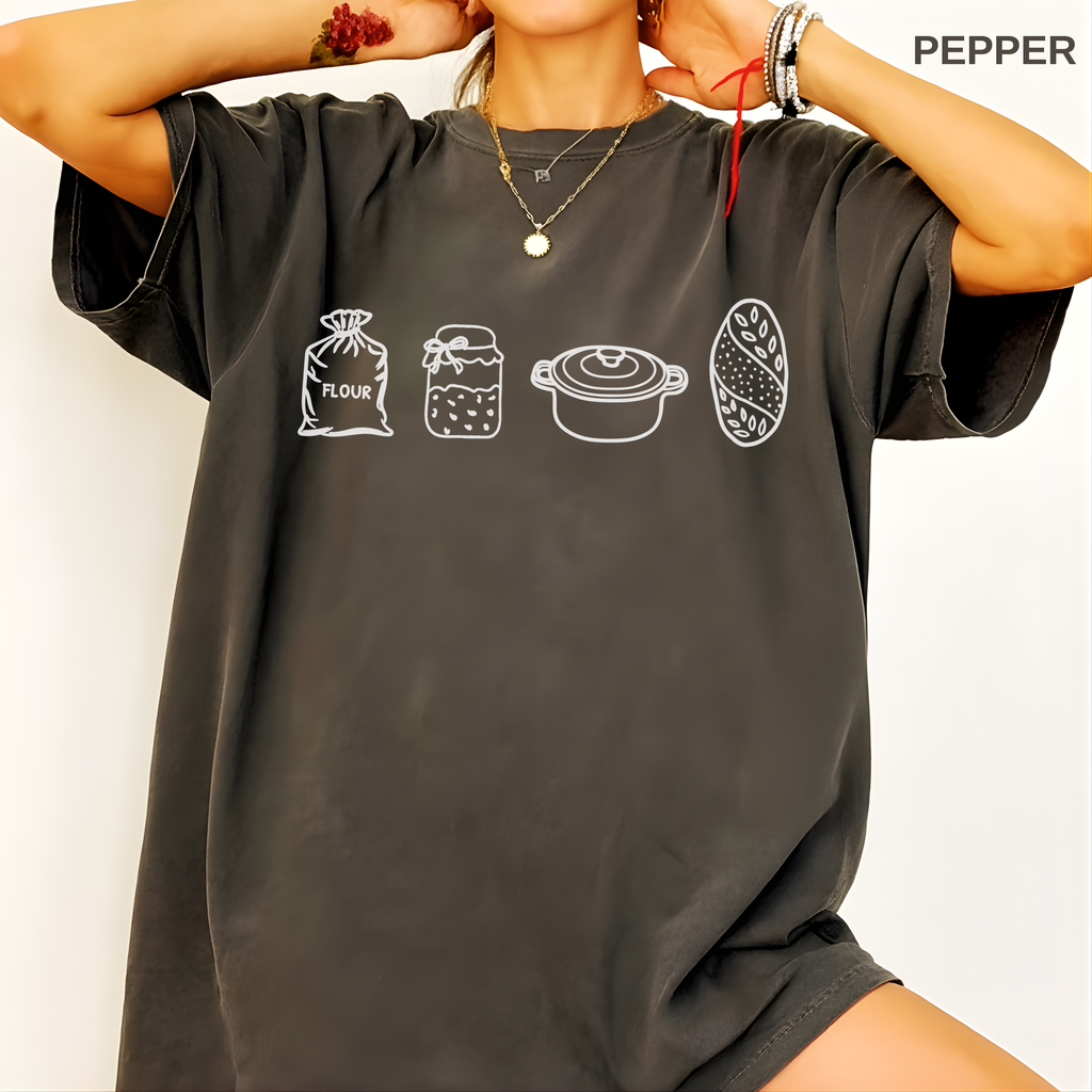 Woman wearing a sourdough baker shirt while preparing bread in a warm home kitchen.