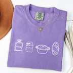 Violet sourdough baker shirt with flour, starter, Dutch oven and bread illustrations.